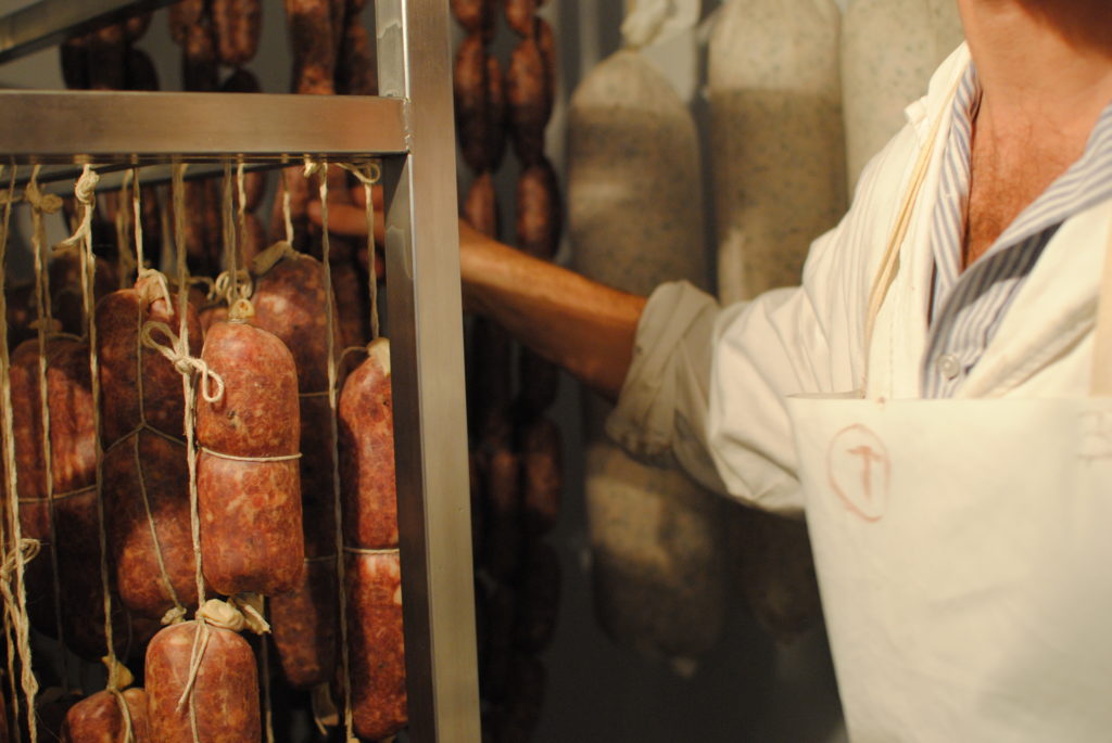 Butcher with hanging salumi