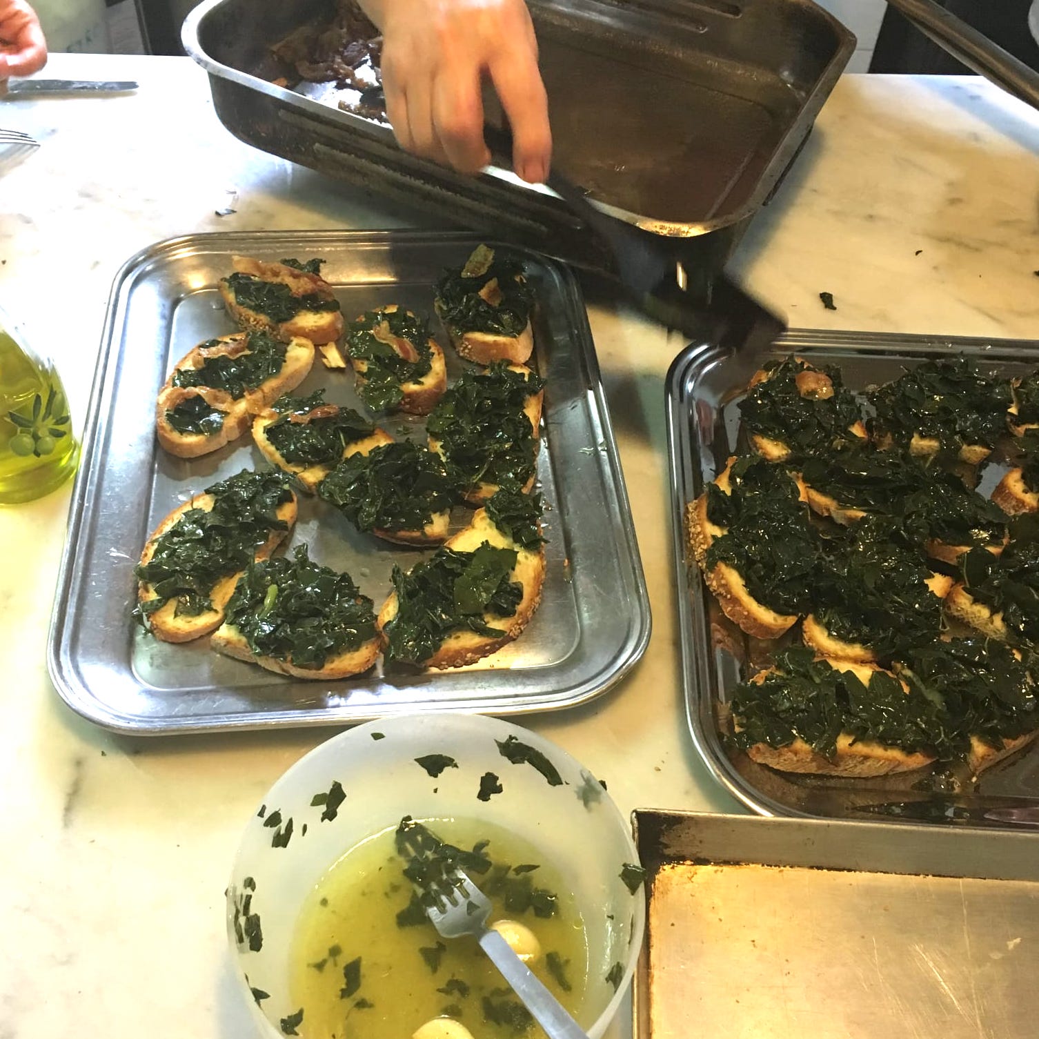Topping thick slices of toasted bread with cooked kale.