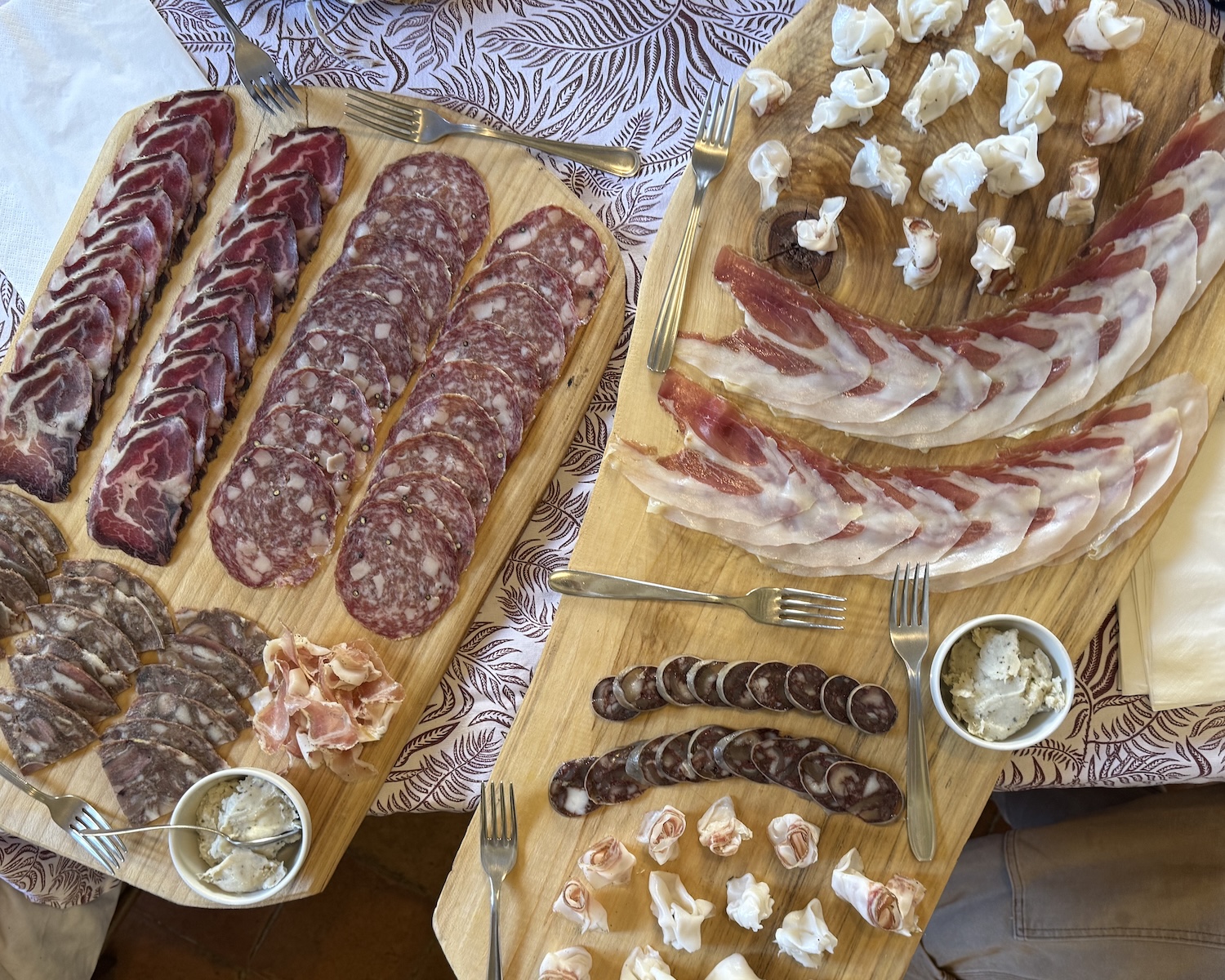 Overhead photo of two wooden boards full of an array of cured meats.
